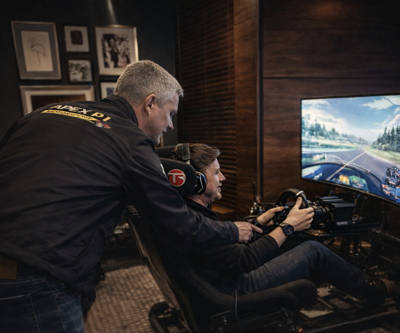 Apex P1 host coaching a guest on a racing simulator